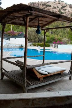 Deck chairs under a canopy stand near the swimming pool. Lounge chairs in hotel Stock Photos