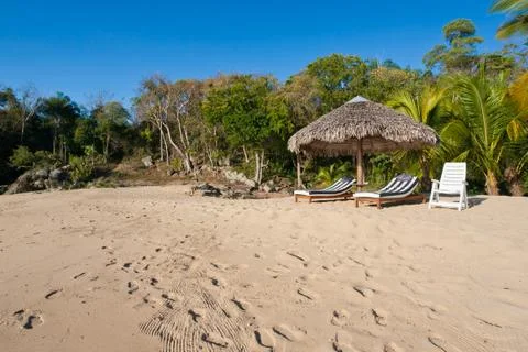 Deck chairs under umbrella Stock Photos