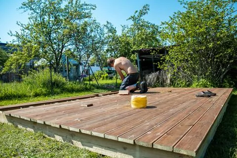Deck construction, builder hand with electric screwdriver installing impreg.. Foto stock