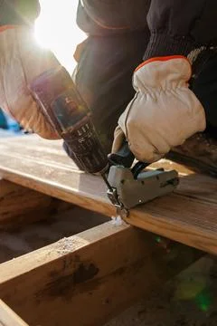 Deck construction close up worker fastening boards with drill and nailer Foto stock