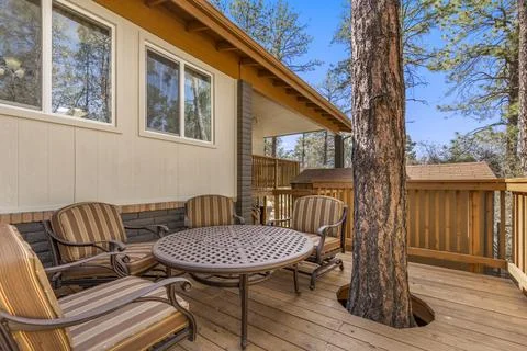 On the deck of a cozy house, there is a table accompanied by chairs Stock Photos