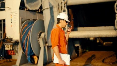 Deck Officer on deck of offshore vessel holds VHF walkie-talkie radio Stock Footage 108640270