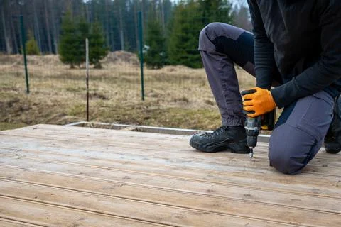 Deck or terrace construction, builder hand with electric screwdriver instal.. Foto stock