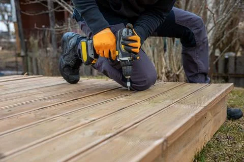 Deck or terrace construction, builder hand with electric screwdriver instal.. Foto stock