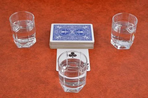 A deck of playing cards and stacks of vodka on the table Stock Photos