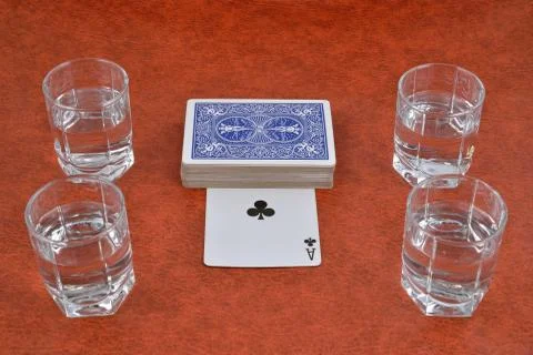 A deck of playing cards and stacks of vodka on the table Stock Photos