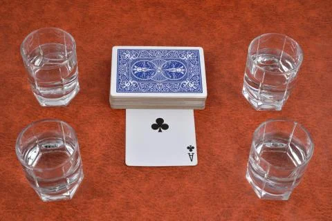 A deck of playing cards and stacks of vodka on the table Stock Photos