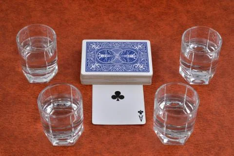 A deck of playing cards and stacks of vodka on the table Stock Photos