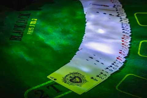 Deck of playing cards on the green table for Blackjack lighted with party lig Stock Photos