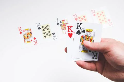 A deck of playing cards in hand. The player deals cards. Poker game. Stock Photos