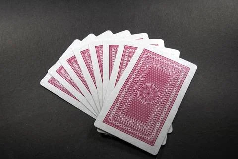 Deck of playing cards with red backside isolated on black background Stock Photos