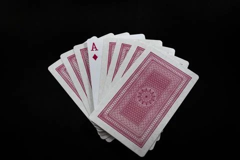 Deck of playing cards with red backside isolated on black background Stock Photos