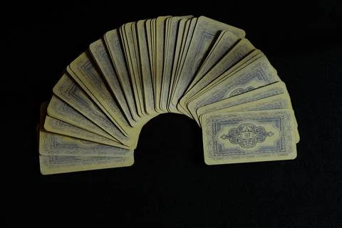 A deck of playing or fortune-telling cards spread out in a fan on a black Stock Photos