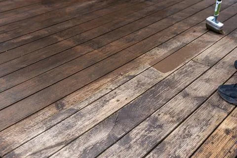 Deck refinishing in progress with roller applicator and test patch Stock Photos