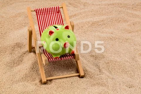 Deckchair with piggy bank Stock Photos