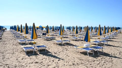 Deckchairs and parasols on sandy beach near the sea. Exotic beach in summer Stock Footage 211523042