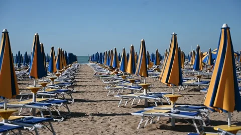 Deckchairs and parasols on sandy beach by the sea. Stock Footage 274320104