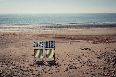 Deckchairs on a deserted beach Photos
