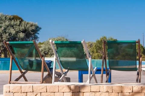 Deckchairs by the pool Stock Photos
