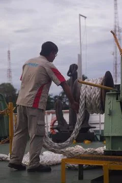 A deckhand casting off the mooring line as the vessel prepares to depart Fotos de archivo