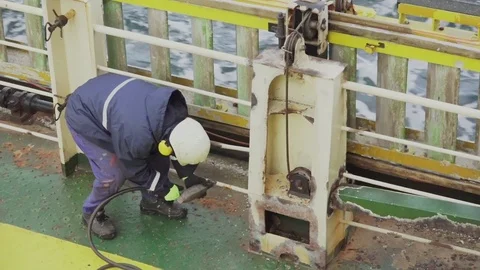 Deckhand removes rust with inflation needle gun on tanker Stock Footage 121117462