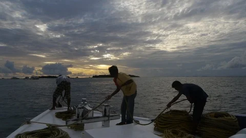 Deckhands pulling in mooring while line standing on bow of boat Video stock 123402649