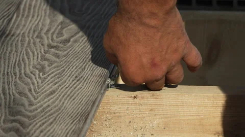 Decking Installation Construction worker hand installing grey composite board on Stock Footage 313609441