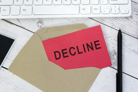 Decline text on red card with envelope, white keyboard and pen on wooden tabl Stock Photos