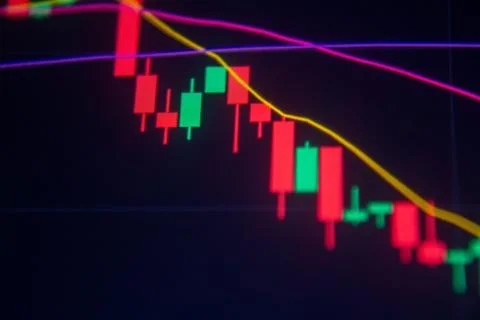 A declining candlestick chart with red and green bars on a dark background. Stock Photos