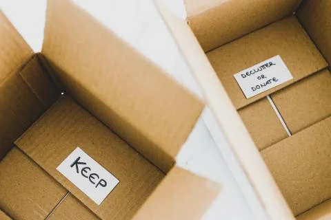 Decluttering concept, storage boxes to sort between objects to keep and those Stock Photos