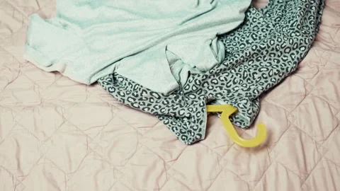 Decluttering process: Woman taking clothes on hangers out of wardrobe and puttin Stock-Footage 332440647