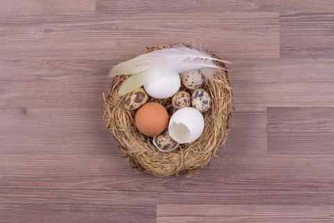 Deco easter nest basket with eggs feathers on wooden background. Beautiful de Foto stock