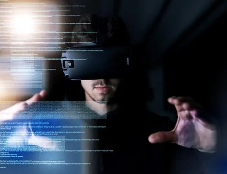 Decoding virtual reality. a young computer programmer wearing a vr headset while Stock Photos