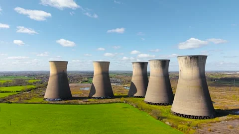 Decommissioned nuclear station with multiple cooling towers above green fields Stock Footage 344867727