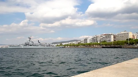 Decommissioned old warship on the coast , clouds  and residential buildings Stock Footage 116974572