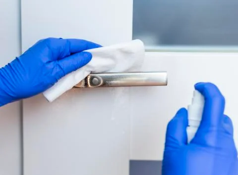 Decontaminating the surface of the door handle. Stock Photos