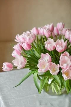 Decor and a vase with pink tulips on a table Stock Photos