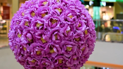 Decor of artificial flowers in the shape of a ball in artificial light Stock Footage 105987374