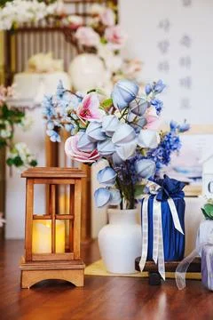 Decor elements in a floral arrangement with a lantern on display 스톡 사진