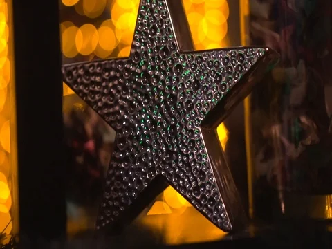 Decor. Gold star on bokeh background. Lots of lights. A three-dimensional star.  Stock Footage 84530484
