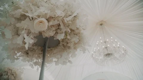 Decor over a table of flowers on the background of the chandelier Stock Footage 119306835