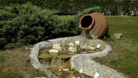 The decor in the Park. From a large jug of water flows and becomes a small Video stock 92149396