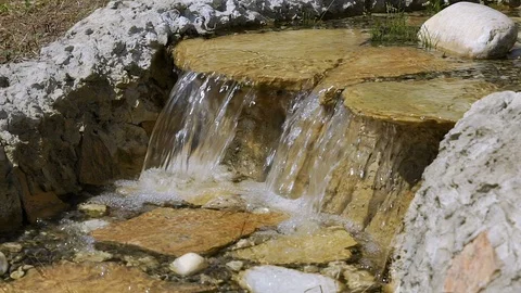 Decor in the Park, a small waterfall, slow motion water falls from the rocks. Video stock 92156326