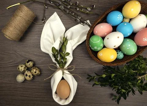 Decor for serving the Easter table. Easter eggs in a wicker basket and willow 库存照片