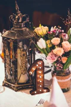 Decor on the table with old night lamp, flowers and number one Stock Photos