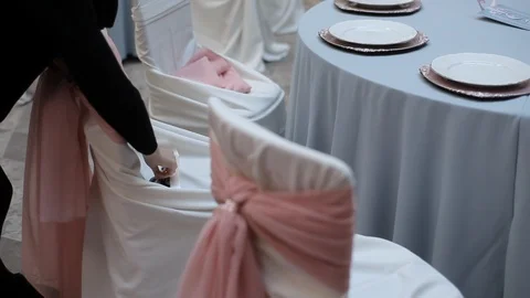 Decor for wedding room table setting with glasses, plates, flowers and chairs Stock Footage 105000674