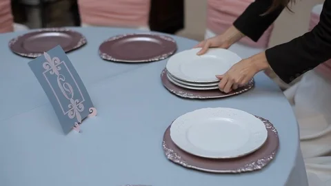 Decor for wedding room table setting with glasses, plates, flowers and chairs Stock Footage 105000903