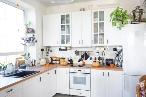 Decor of the white classic kitchen with pumpkins for Halloween and harvest... Foto stock