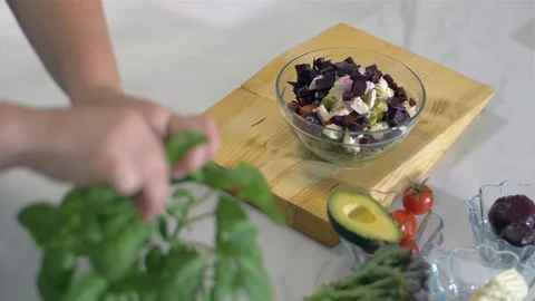 Decorate a fresh salad with basil Stock Footage 111417827