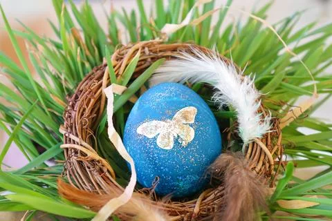 Decorated Blue and Gold Easter Egg in a Rustic Nest with Grass Stock Photos